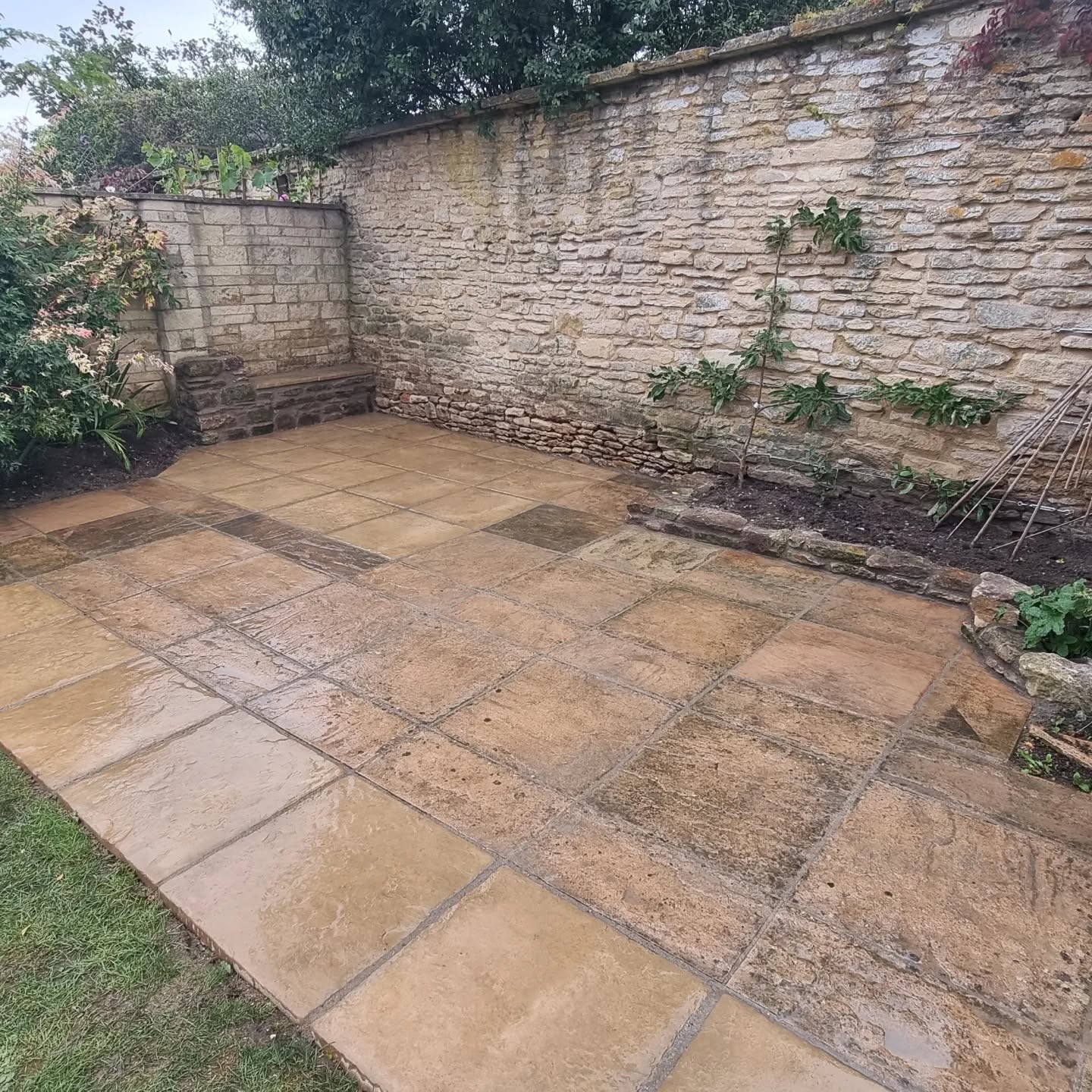 Wet sandstone patio in an old stone-walled garden