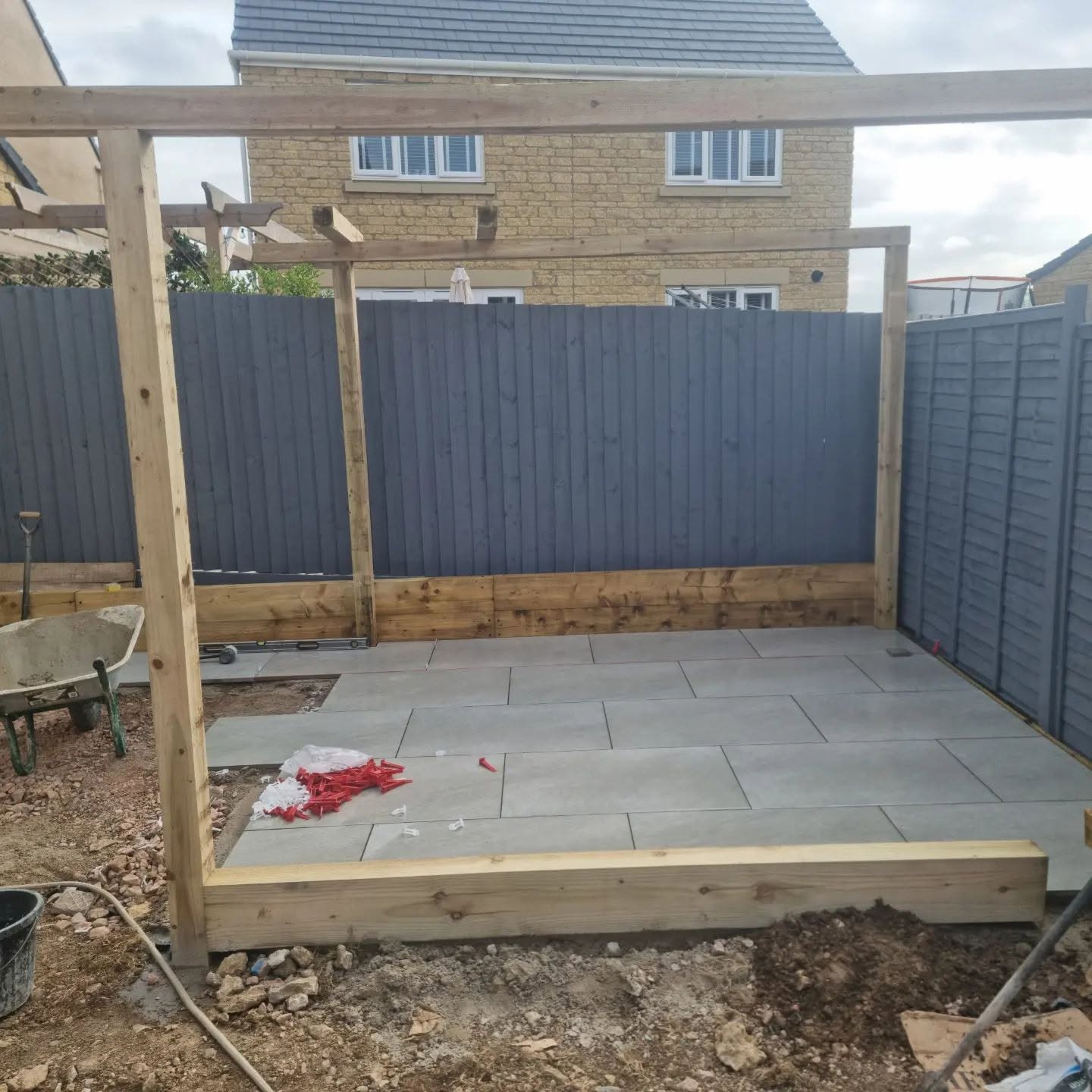 Timber pergola frame going up over a new patio