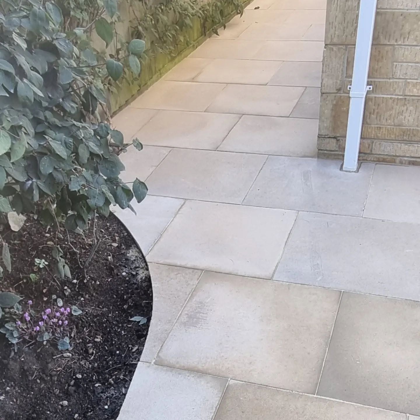 Finished cream sandstone paving with a curved border edge